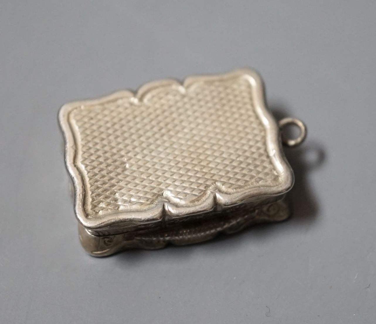 A Victorian engraved silver shaped rectangular vinaigrette, Edward Smith, Birmingham, 1847, 27mm.